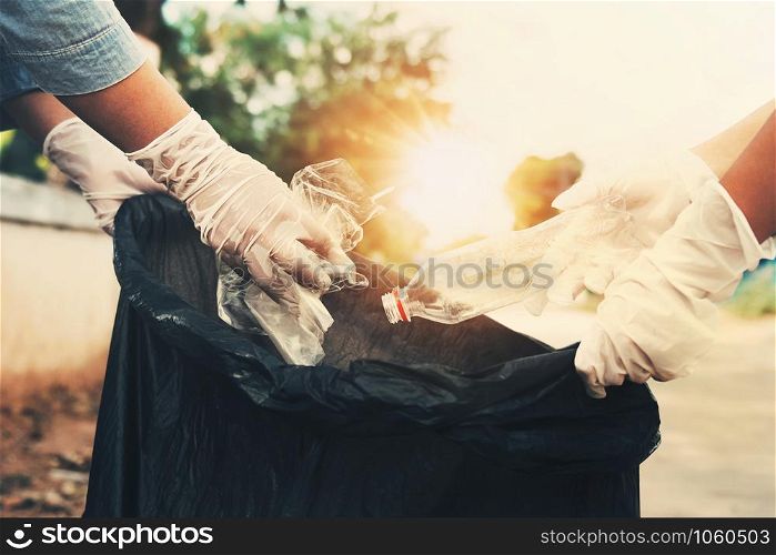 woman hand picking up garbage plastic bottle for cleaning at
