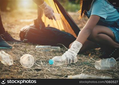 woman hand picking up garbage plastic bottle for cleaning at park