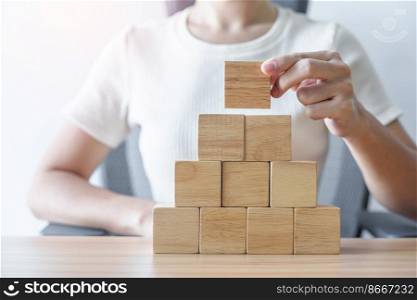 Woman hand placing wood block on the building. Leadership, Business process planning, Risk Management and strategy Concepts