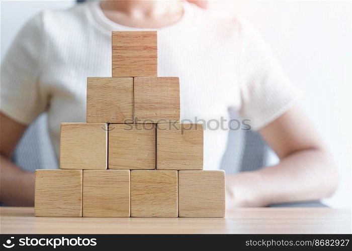 Woman hand placing wood block on the building. Leadership, Business process planning, Risk Management and strategy Concepts