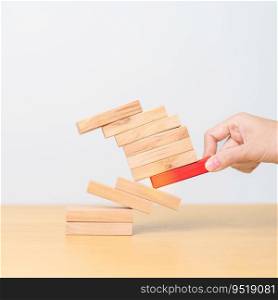 woman hand pulling wood domino blocks on table. Crisis, fall Business, Risk management, Economic recession, Strategy and solutions concept