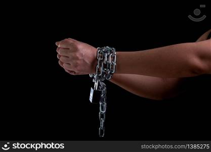 Woman hand tied up with steel chain and lock at the black background, Human rights violations and International women&rsquo;s Day concept, Front view women