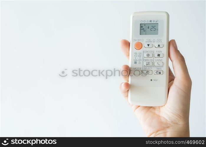 Woman hand using remote control open air conditioning 25 degrees. Open air 25 degrees, is temperature, save energy