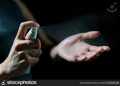 Woman hand using sanitizer spray, alcohol spraying disinfectant to stop spreading coronavirus or COVID-19.