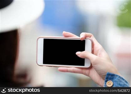 Woman hand using smart phone with blank screen over blur background, business and technology, network online mock up background