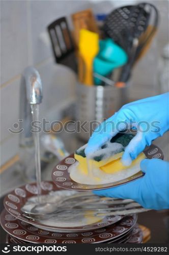Woman hand washing dishes in the kitchen