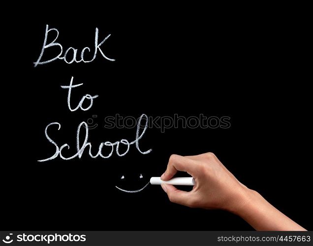 "Woman hand writing on blackboard phrase :"back to school", female body part, start of educational season concept"