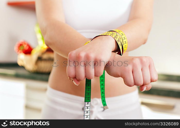 Woman handcuffed by a tape measure - symbol for eating disorder