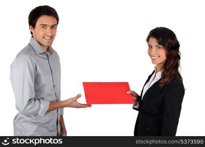 Woman handing folder to man