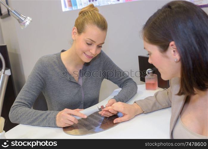 woman hands being nail filed by manicurist