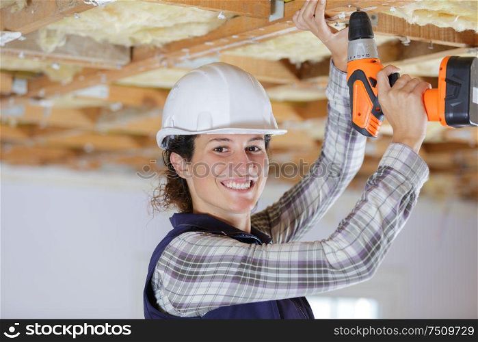 woman hands drilling wood plank indoors