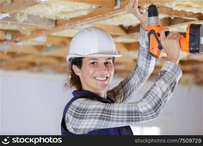woman hands drilling wood plank indoors