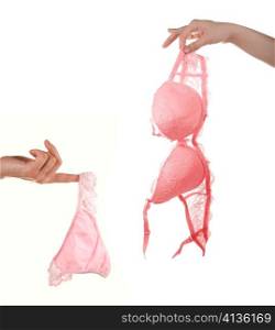 Woman hands hold pink bra and pants isolated on white background