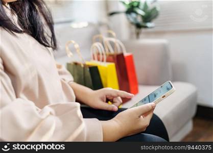 Woman hands holding cell telephone using smartphone
sale shopping bags. consumerism lifestyle concept in the shopping mall with shopping bag