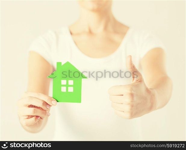woman hands holding green house showing thumbs up. woman hands holding green house