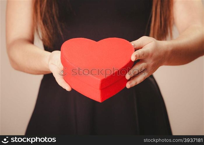 Woman hands holding heart. Love help and charity. Woman hands holding red heart box present gift in studio.