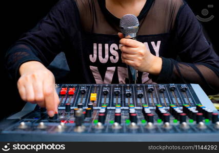 Woman hands holding microphone and mixing audio by sound mixer analog in the recording studio