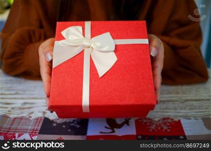 Woman hands holding red gift box.