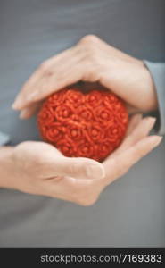 Woman hands holding red sweetheart. Vertical photo