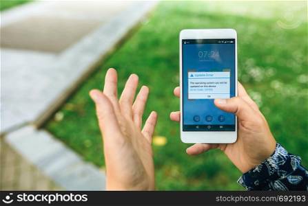 Woman hands holding smartphone with update error text on the screen. English text in dialog box.
