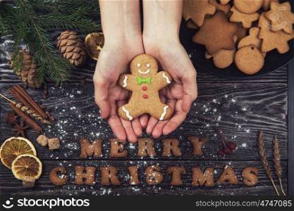 Woman hands keep ginger cookies. Woman hands keep ginger cookies for new years and christmas on wooden background.
