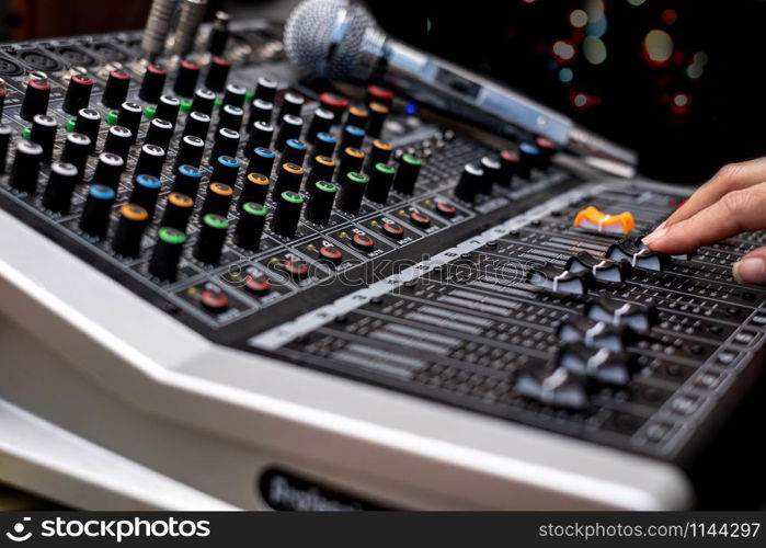 Woman hands mixing audio by sound mixer analog in the recording studio