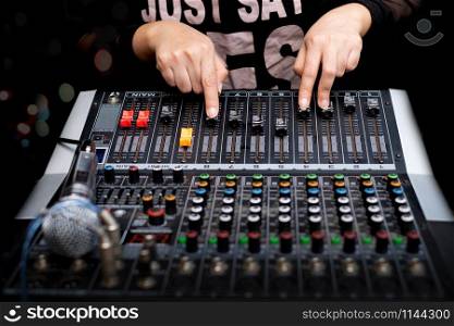 Woman hands mixing audio by sound mixer analog in the recording studio