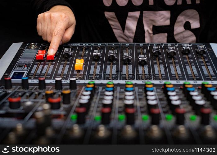 Woman hands mixing audio by sound mixer analog in the recording studio