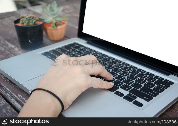 woman hands on a laptop at wood table.