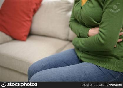 Woman Hands On Front Stomach Painful on Couch