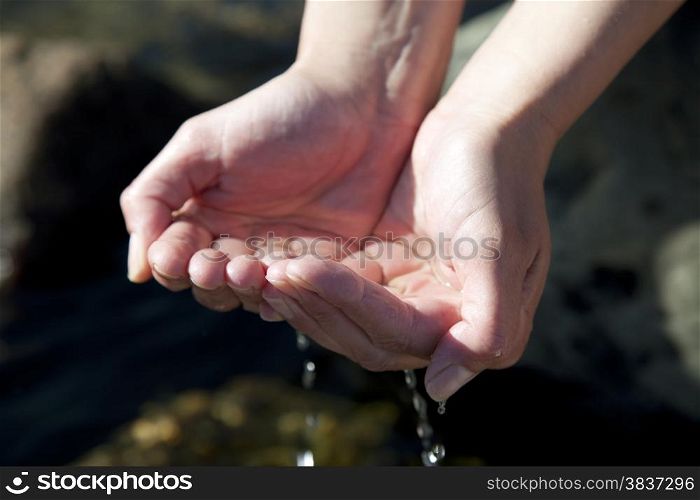 Woman hands playing with natural water