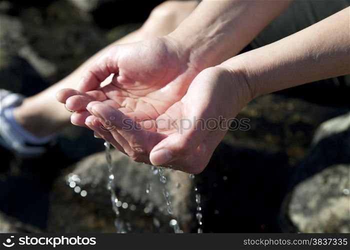 Woman hands playing with natural water