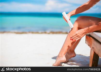 Woman hands putting sunscreen from a suncream bottle background the sea. girls apply hands sunscreen bottle background turquoise water