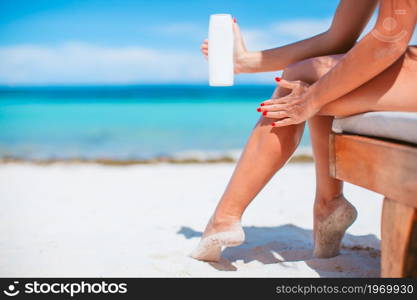 Woman hands putting sunscreen from a suncream bottle background the sea. girls apply hands sunscreen bottle background turquoise water