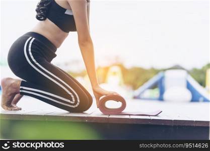 Woman hands rolled up yoga mat outdoor workout. Close up hands rolling foam yoga gym mat outside morning exercise. Woman stretching workout sportive healthy lifestyle on street city town park concept