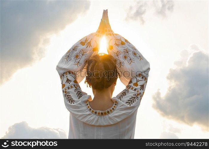 Woman, hands symbolize prayer and gratitude. Wise Yoga concept. Silhouette of female hands against background of cloudy sky and sun. Beautiful scene.. Female hands against in namaste, prayer and gratitude. Wise Yoga concept.