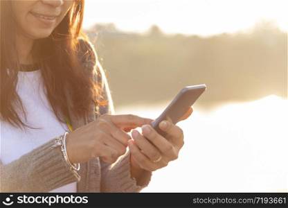 Woman hands texting smartphone mobile using cellphone with smart technology lifestyle. woman social addict communicate by internet on sunrise