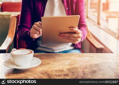Woman hands using and holding  computer tablet in coffee shop with vintage toned.