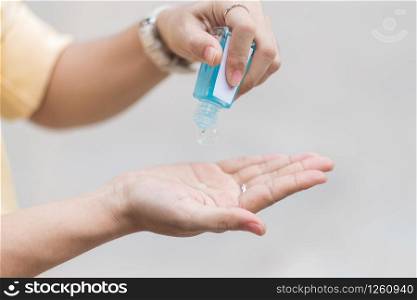 Woman hands using wash hand sanitizer gel dispenser, against Novel coronavirus or Corona Virus Disease (Covid-19) at public train station. Antiseptic, Hygiene and Healthcare concept