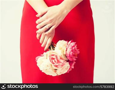 woman hands with bouquet of flowers and wedding ring.
