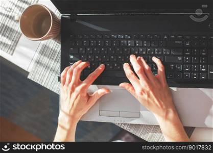 woman hands with cup of coffee or tea using laptop. girl at office is typing on a laptop. girl at work. hands on keyboard close. woman hands with cup of coffee or tea using laptop. girl at office is typing on a laptop. hands on keyboard close