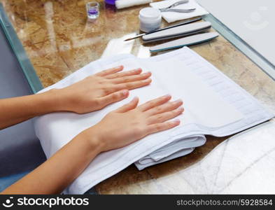 woman hands with nails before treatment on white towel in salon