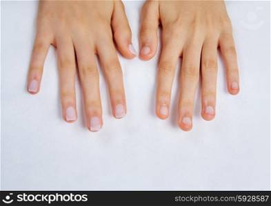 woman hands with nails before treatment on white towel in salon