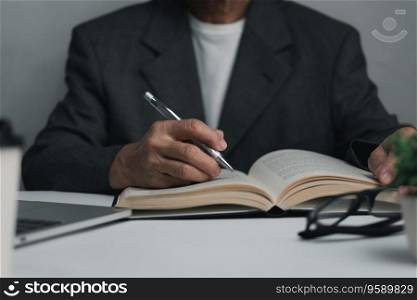 Woman hands with pen writing on notebook in the office.learning, education and work.writes goals, plans, make to do and wish list on desk.