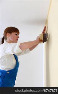 Woman hanging wall-paper