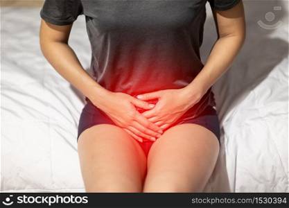woman have bladder or uti pain sitting on bed in bedroom after wake up feeling so illness,Healthcare concept