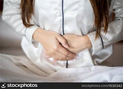 woman have bladder pain sitting on bed in bedroom after wake up,Healthcare concept