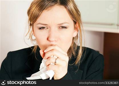 Woman having a cold, coughing, holding a handkerchief in front of her face