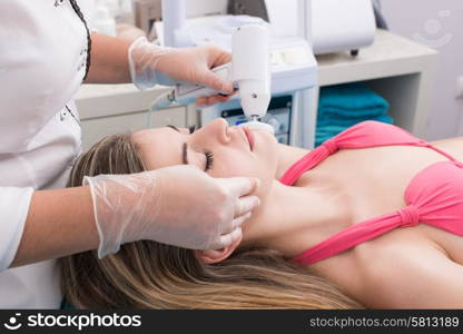 Woman having a facial massage and peeling in beauty salon