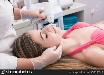 Woman having a facial massage and peeling in beauty salon